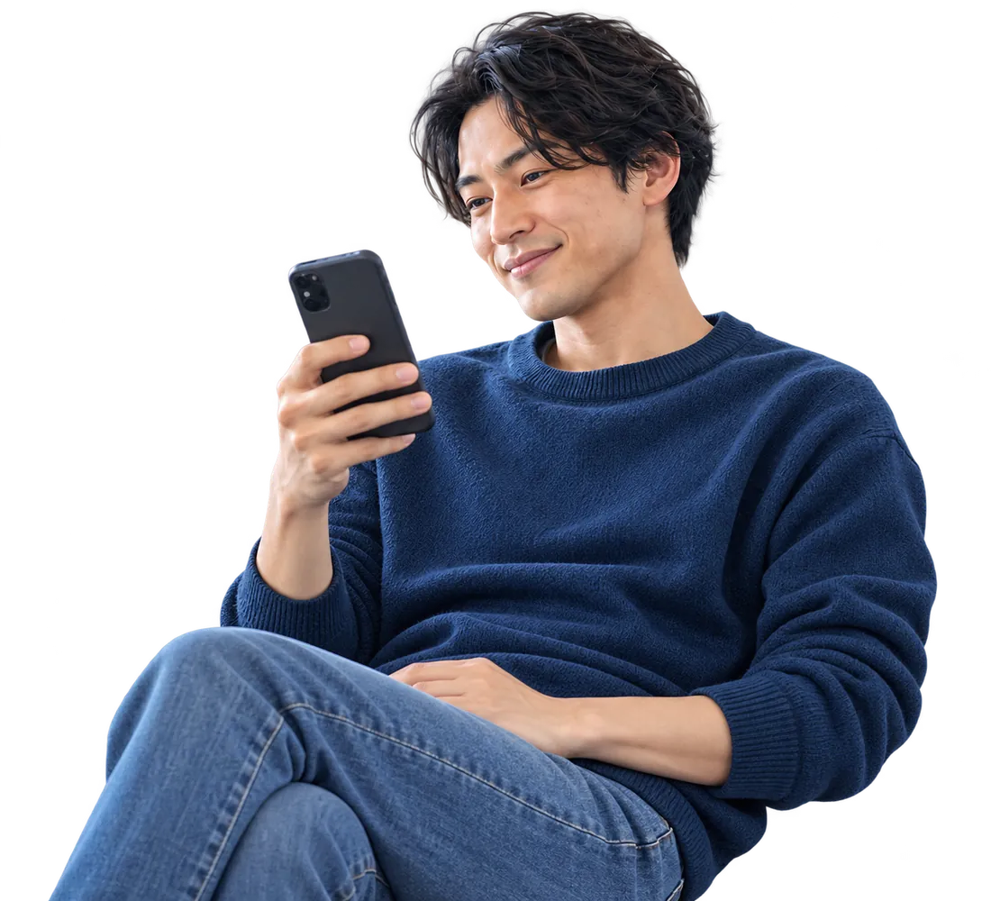 自宅でくつろぎながらスマートフォンを見ている男性