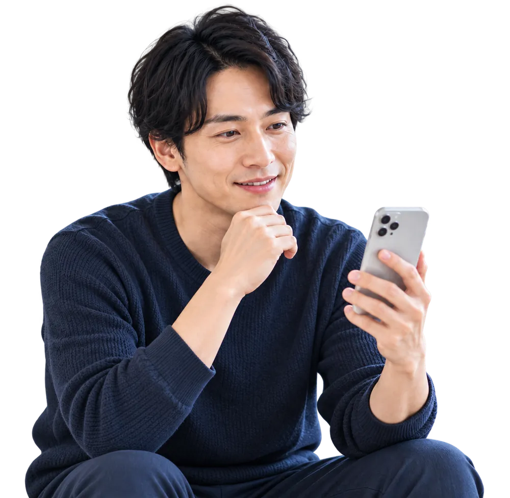 自宅のソファでスマートフォンを見ながら考えている男性